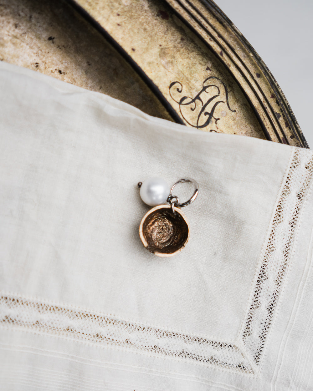 Charm half a nut with a pearl